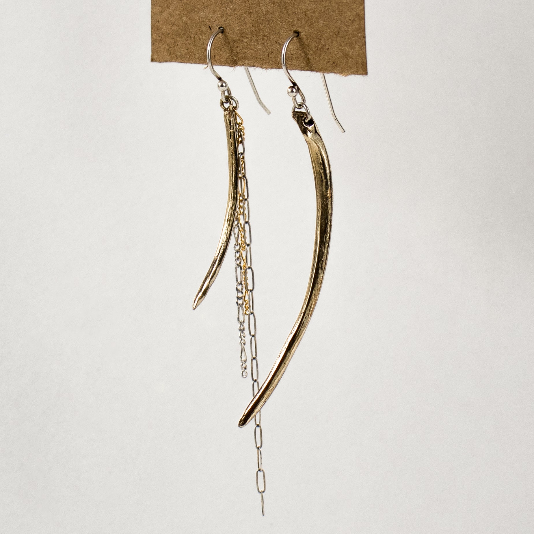 Asymmetrical arc charms measuring 1.5 and 2.25 inches each available in brass or sterling silver with sterling and gold-filled tassels dangling from sterling hooks handmade and finished in our Catskills store-studio