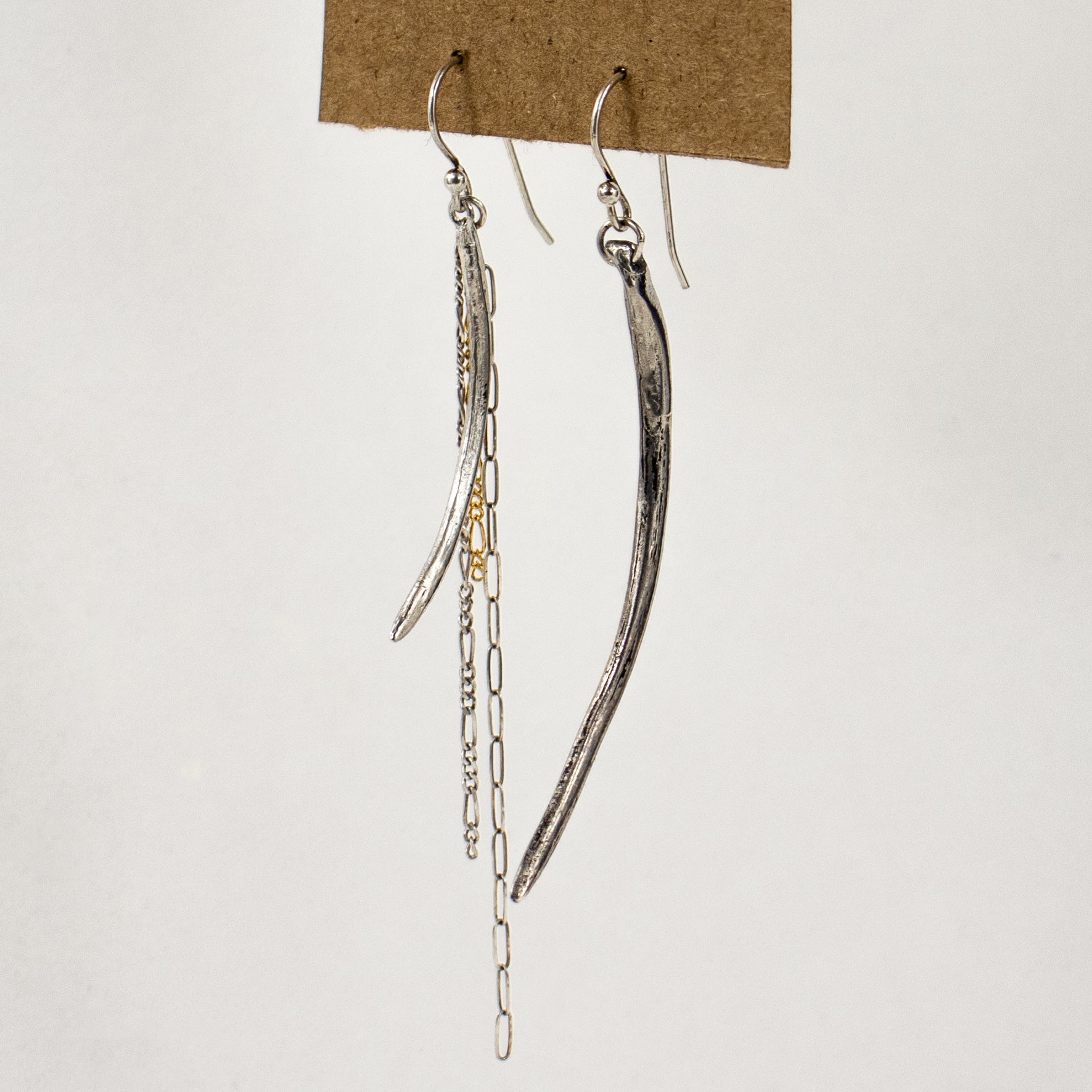 Asymmetrical arc charms measuring 1.5 and 2.25 inches each available in brass or sterling silver with sterling and gold-filled tassels dangling from sterling hooks handmade and finished in our Catskills store-studio