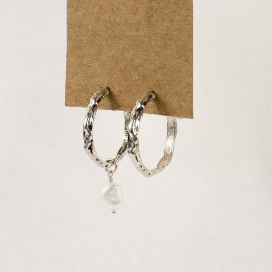 Sterling silver melted hoop earrings available in 1 inch and 0.5 inch diameters with one freshwater pearl handmade and finished in our Catskills store-studio