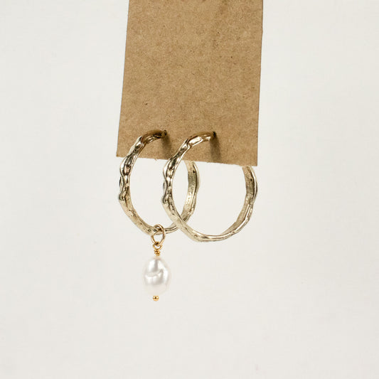 Brass melted hoop earrings available in 1 inch and 0.5 inch diameters with one freshwater pearl and sterling silver posts and backings handmade and finished in our Catskills store-studio