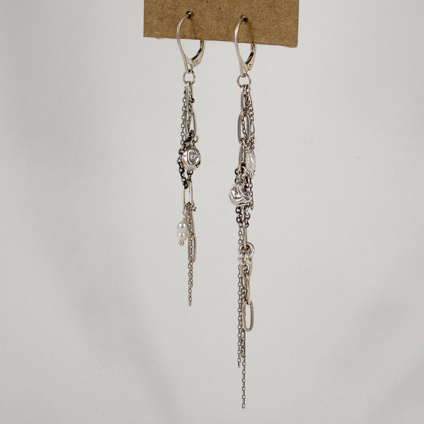 Two reclaimed sterling silver seaweed pods, tangled silver mixed-chain tassels, and freshwater pearls measuring 2 and 2.25 inches each dangling from sterling lever-back hooks handmade and finished in our Catskills store-studio.