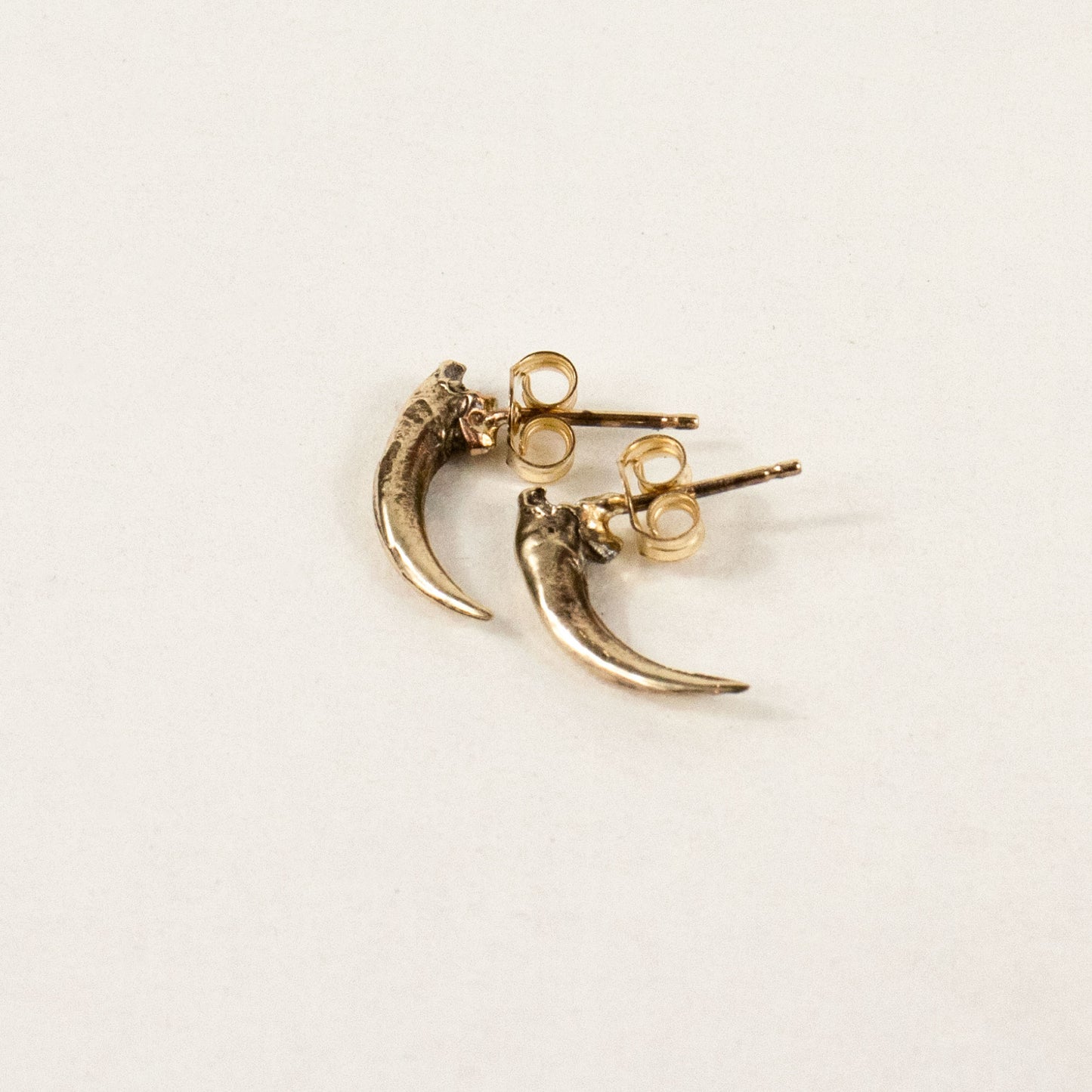 Solid reclaimed 10k gold Icelandic owl claw stud 0.75 inches in length on sterling silver posts handmade and finished in our Catskills store-studio shown on model.