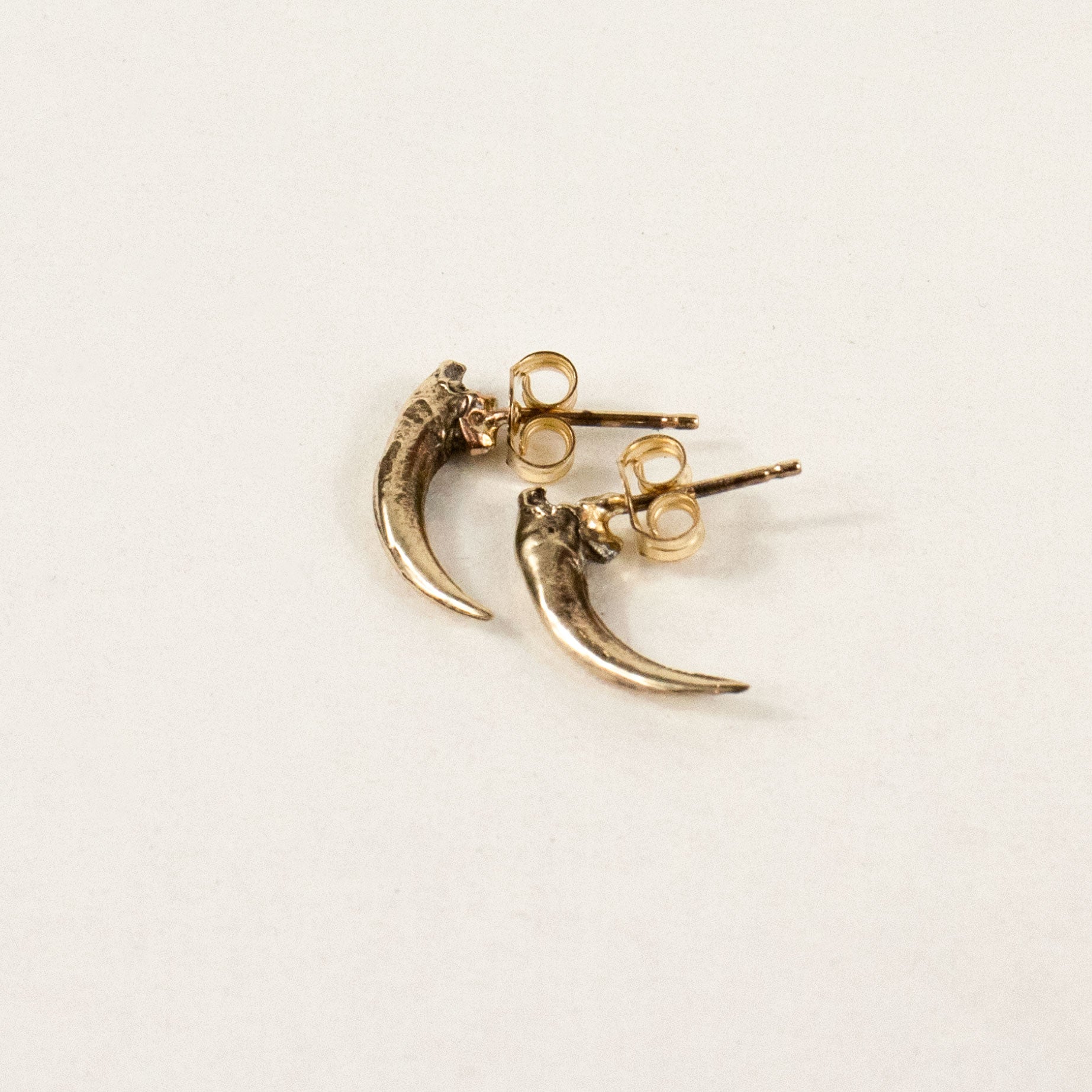 Solid reclaimed 10k gold Icelandic owl claw stud 0.75 inches in length on sterling silver posts handmade and finished in our Catskills store-studio shown on model.