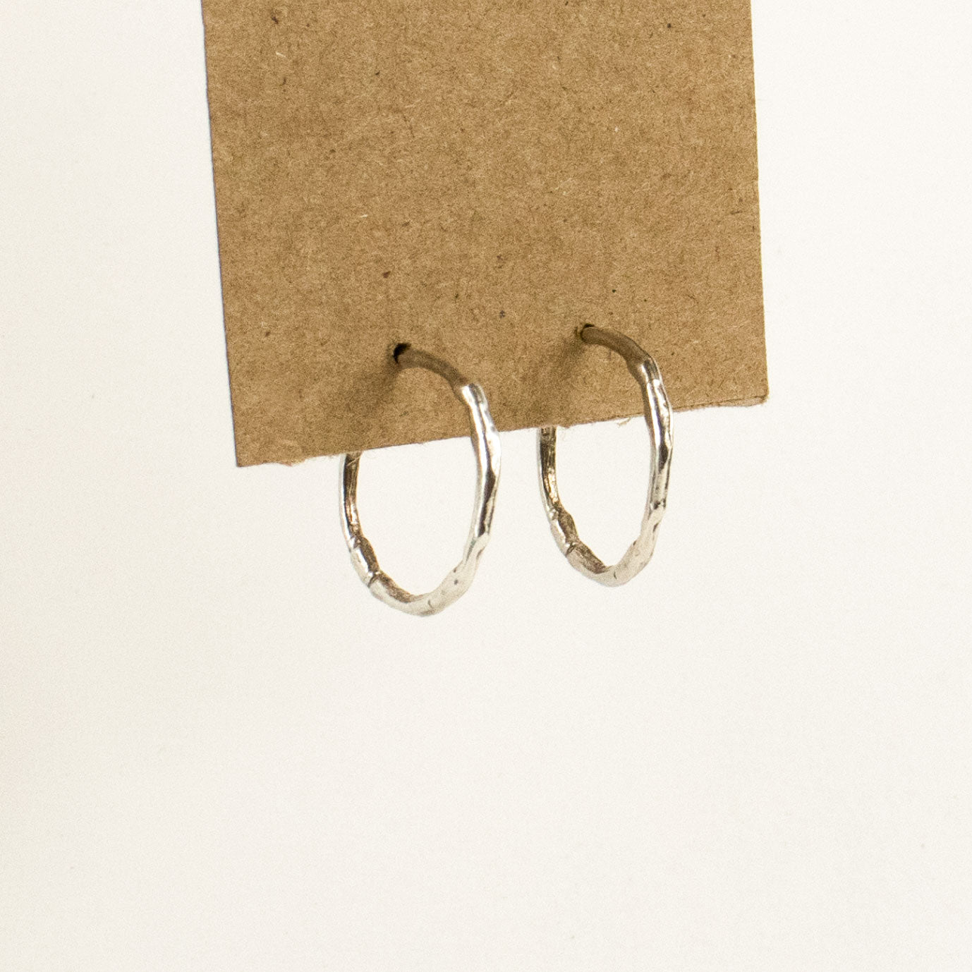 Solid reclaimed sterling silver small branch hoop earrings measuring 1 inch in diameter handmade and finished in our Catskills store-studio shown on model