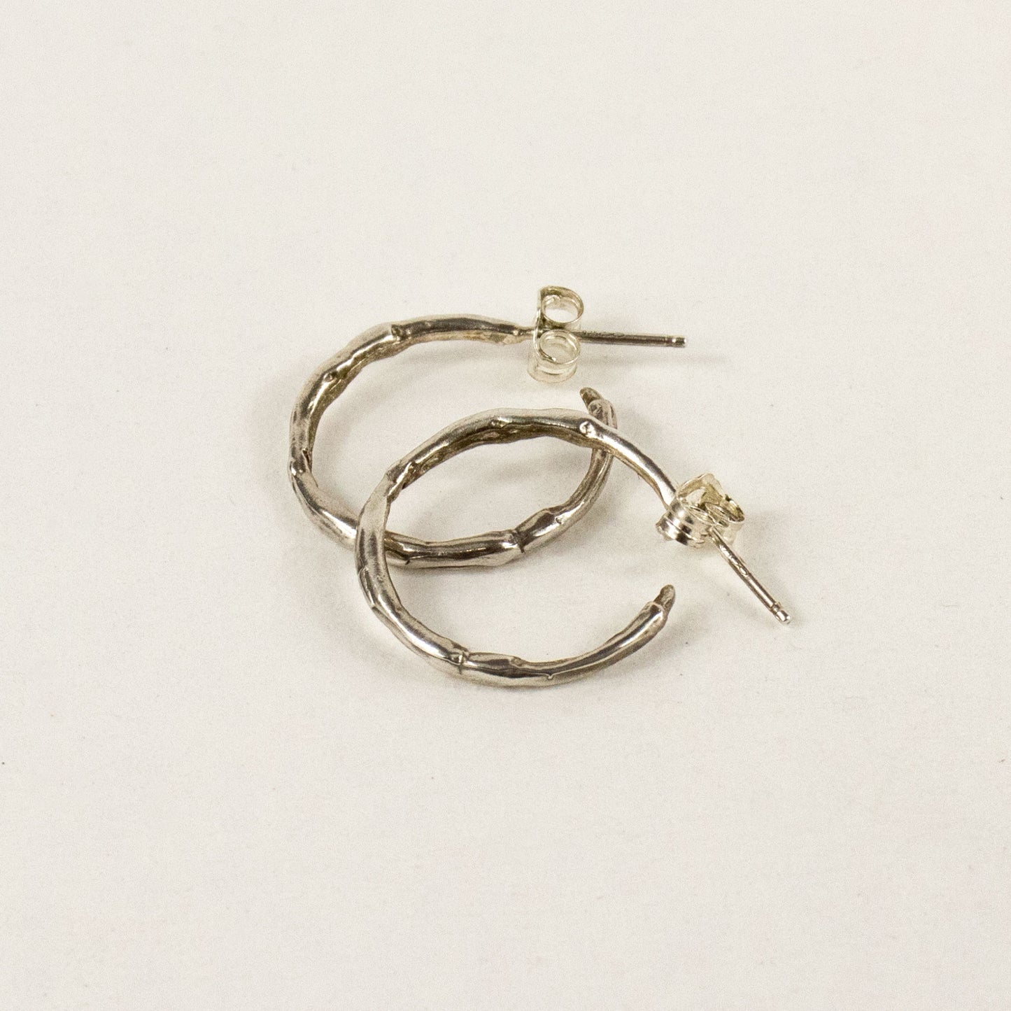 Solid reclaimed sterling silver small branch hoop earrings measuring 1 inch in diameter handmade and finished in our Catskills store-studio