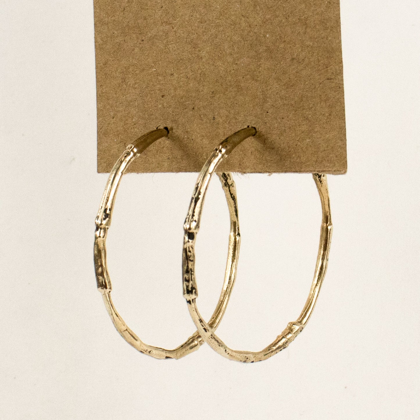 Solid brass large branch hoop earrings measuring 2 inches in diameter with sterling silver posts and handmade and finished in the Catskills store-studio.