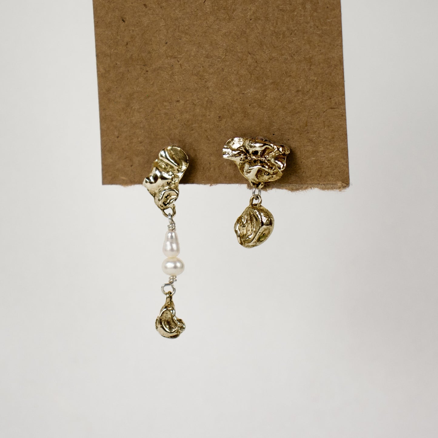 Brass asymmetrical seaweed pods dangling from sterling silver stud earrings beaded with freshwater pearls