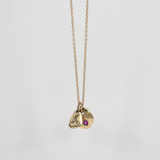 Solid reclaimed 14k gold signature Kria tag and Maine rock 0.5 inch in diameter set with 2mm hot pink sapphire on an 18 inch 14k fine cable-chain.  Made-to-order and finished in our Catskills store-studio.