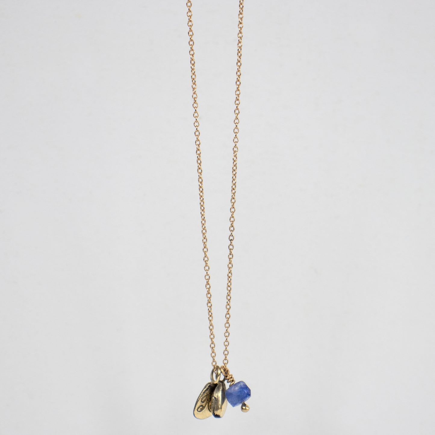 Solid reclaimed 14k gold seed with 4mm blue sapphire bead and 14k Kria signature tag on an 18 inch on 14k fine cable-chain. Handmade and finished in our Catskills store-studio.