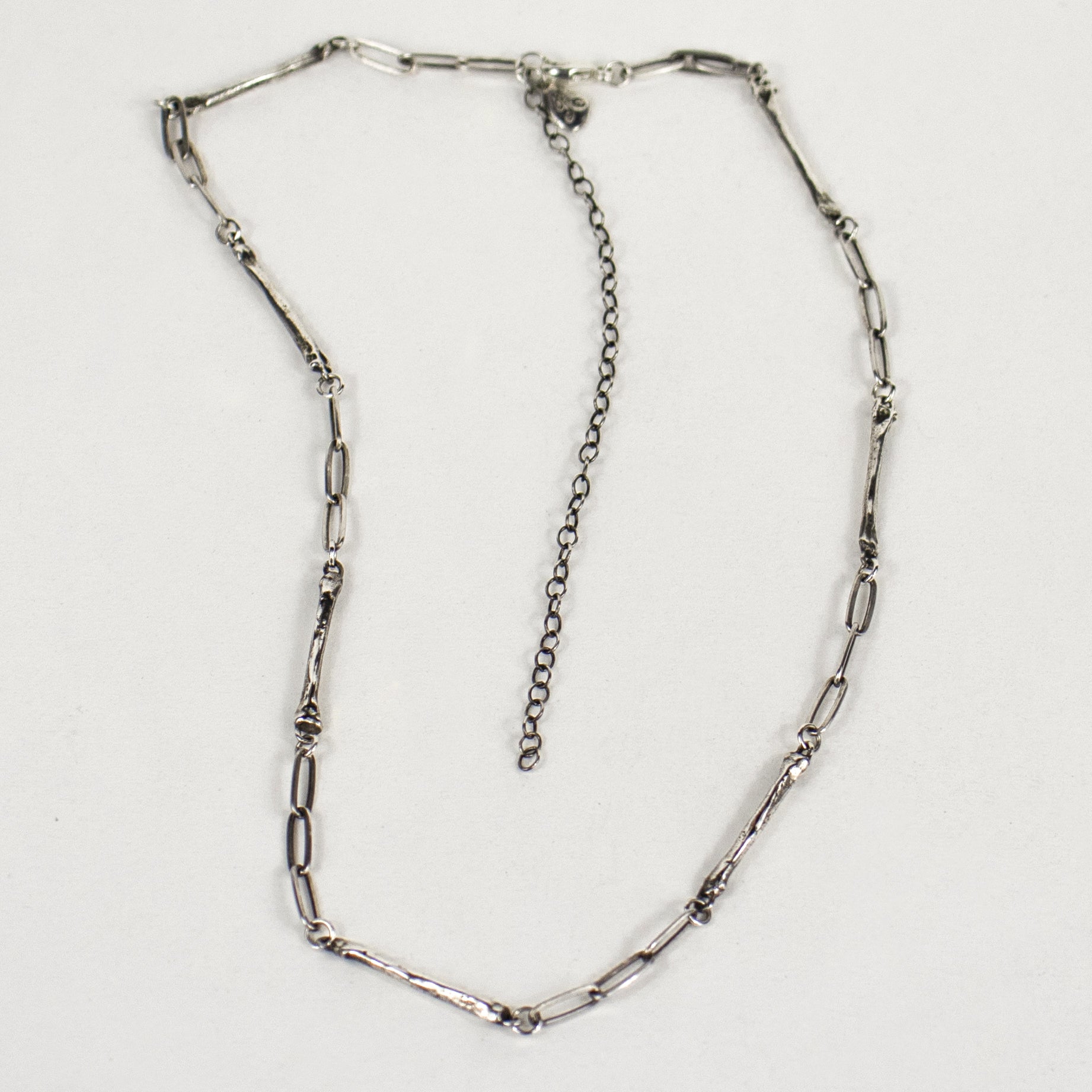 Sterling silver paperclip chain with eight evenly spaced solid reclaimed sterling silver coyote paw bones 0.75 inches each with sterling signature Kria tag and adjustable 14 - 18 inches handmade and finished in our Catskills store-studio.