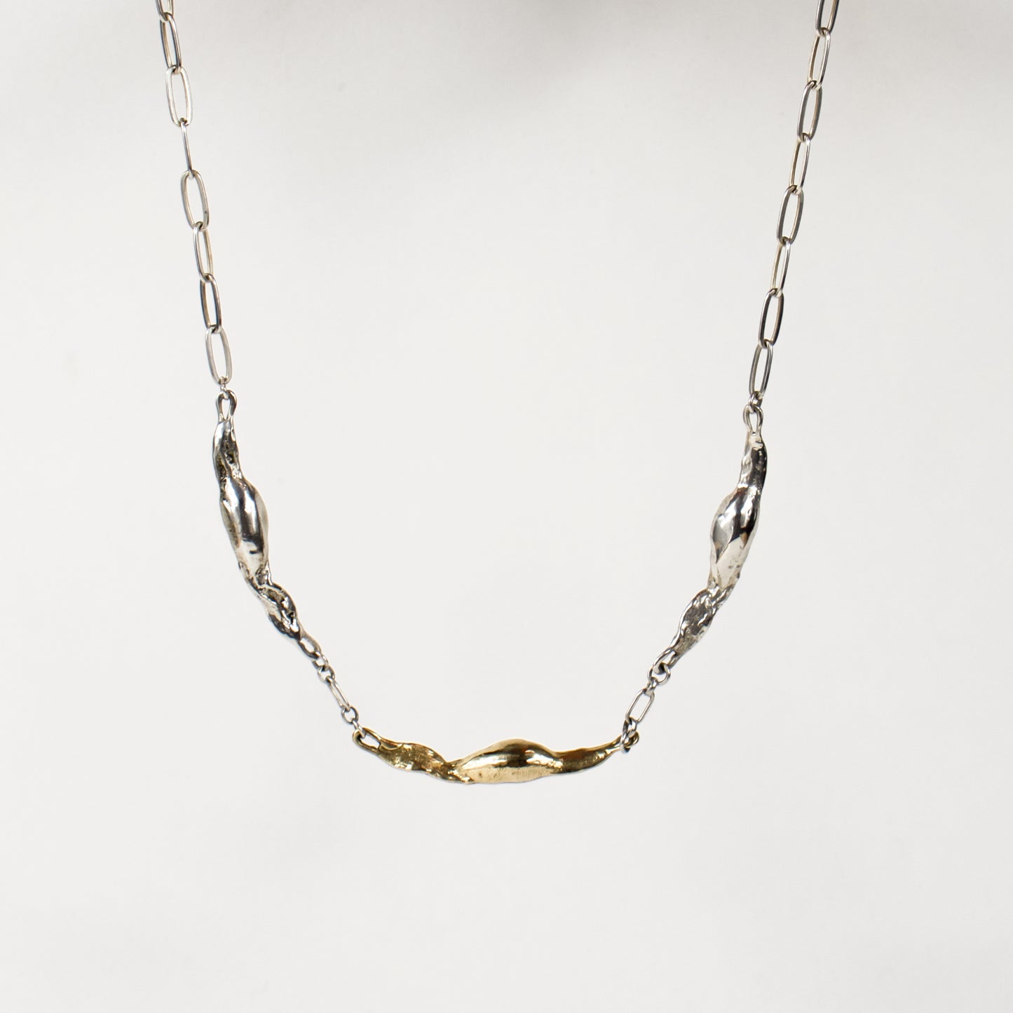 Two sterling silver and one brass seaweed pods measuring 1.5 inches each on sterling silver paperclip chain adjustable 16-18 inches handmade and finished in our Catskills store-studio.