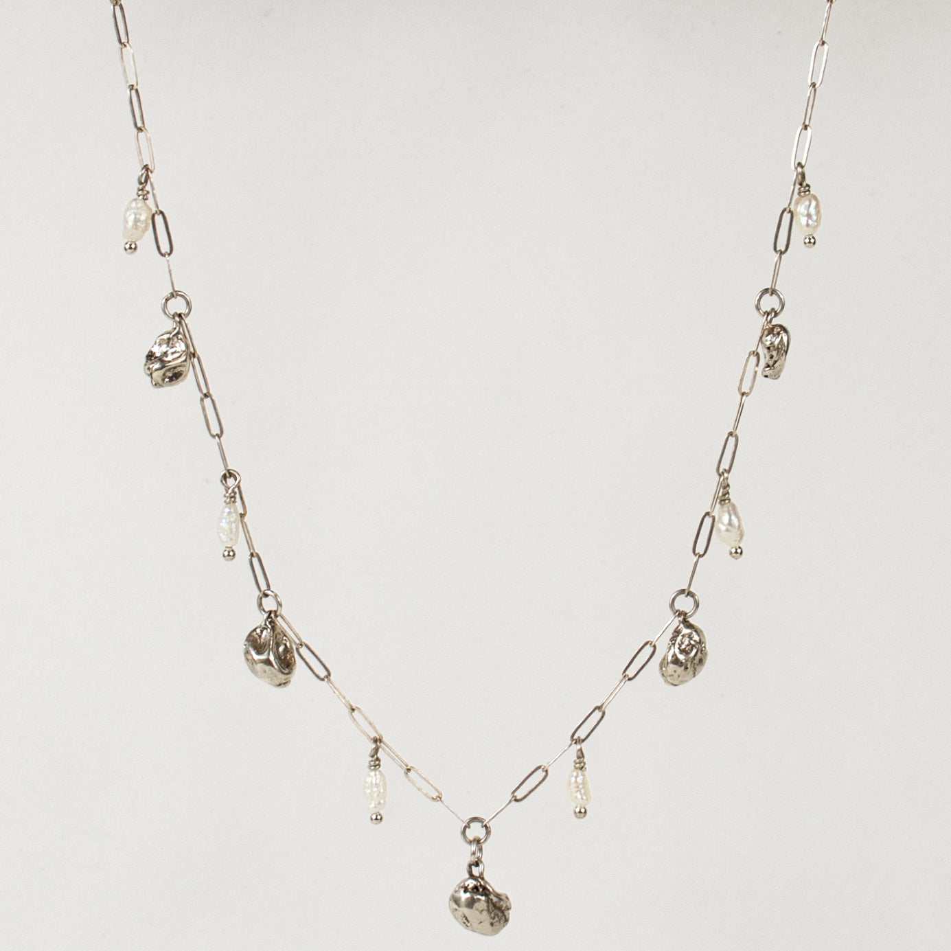 Five reclaimed sterling silver seaweed pods 5 mm each and six 3 mm freshwater pearls on fine sterling paperclip chain adjustable 16-18 inches handmade and finished in our Catskills store-studio.