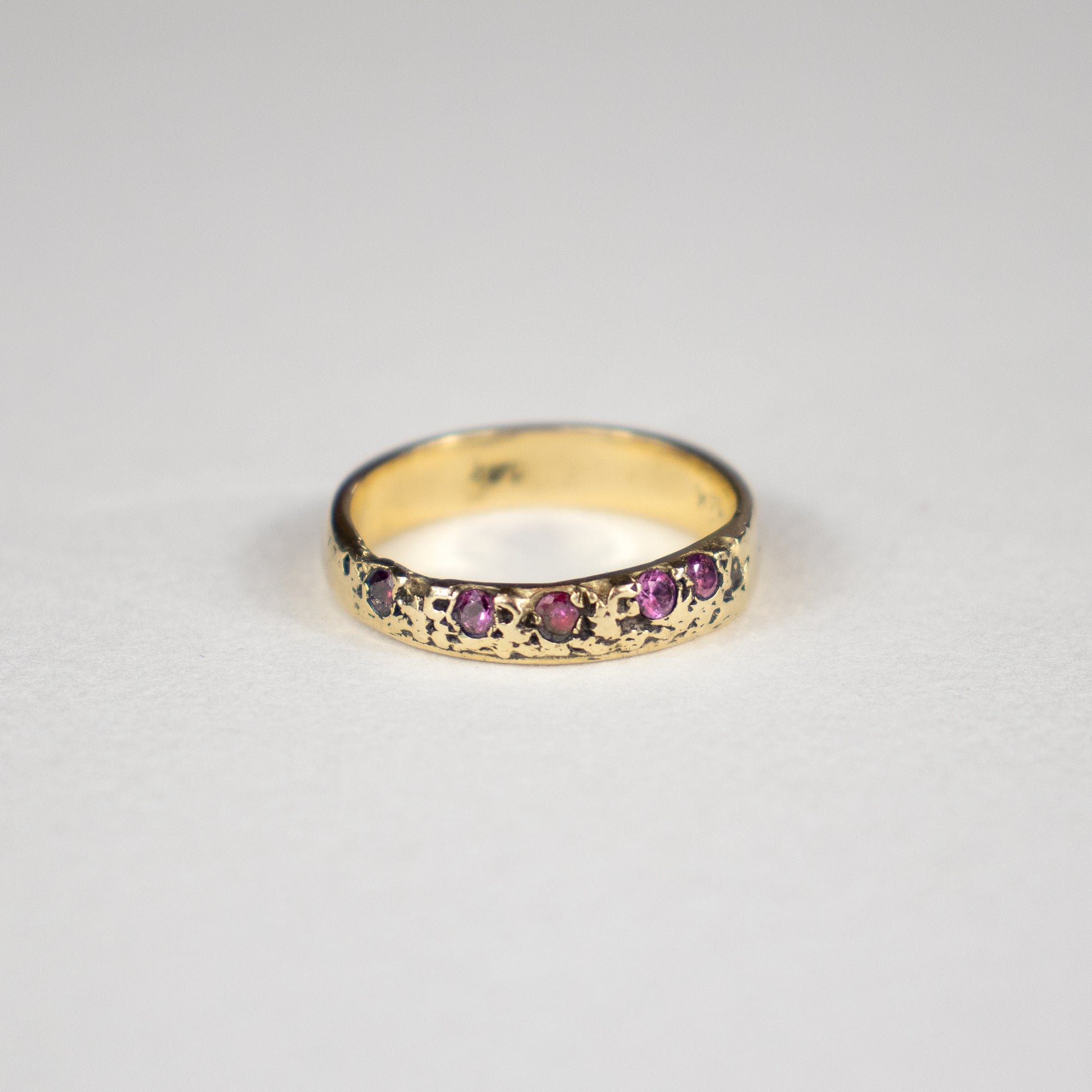 Solid reclaimed 14k gold Vomer ring with a 4mm band-width set with five 2 mm hot pink sapphires.