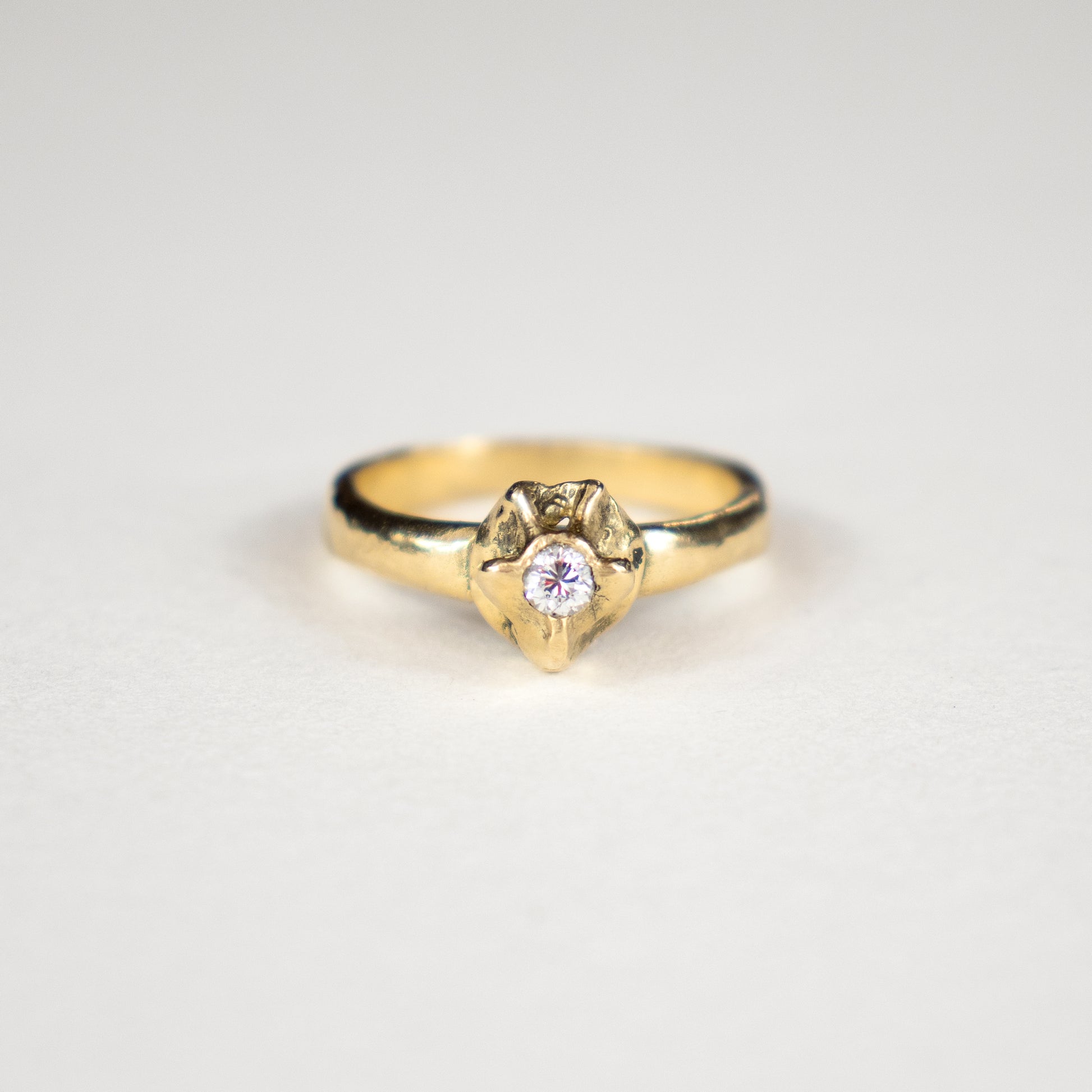 Solid reclaimed 14k gold vertebrae plague ring with 2.5 mm band-width set with a 3 mm diamond.