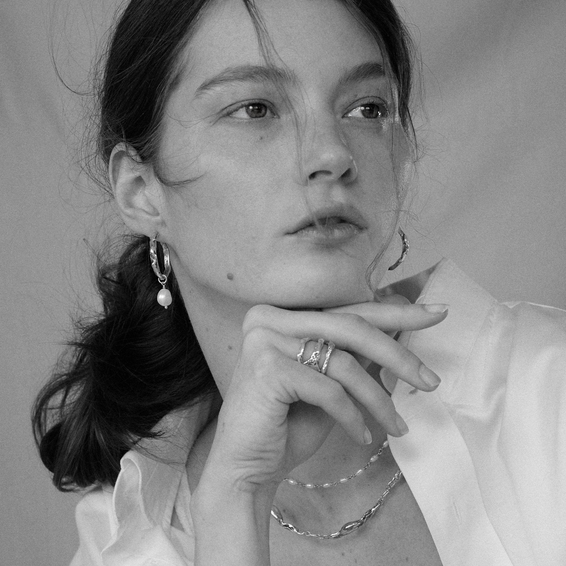 Brass melted hoop earrings available in 1 inch and 0.5 inch diameters with one freshwater pearl and sterling silver posts and backings handmade and finished in our Catskills store-studio