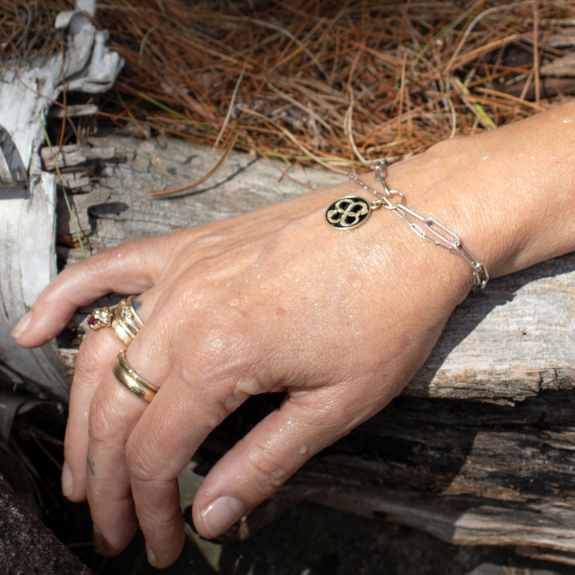 Solid reclaimed 10k gold Serpent Infinity Knot charm 15mm in diameter with your choice of black, lemon cream, or fire red enamel on silver paperclip mixed-chain handmade and finished in our Catskills store-studio shown on model.