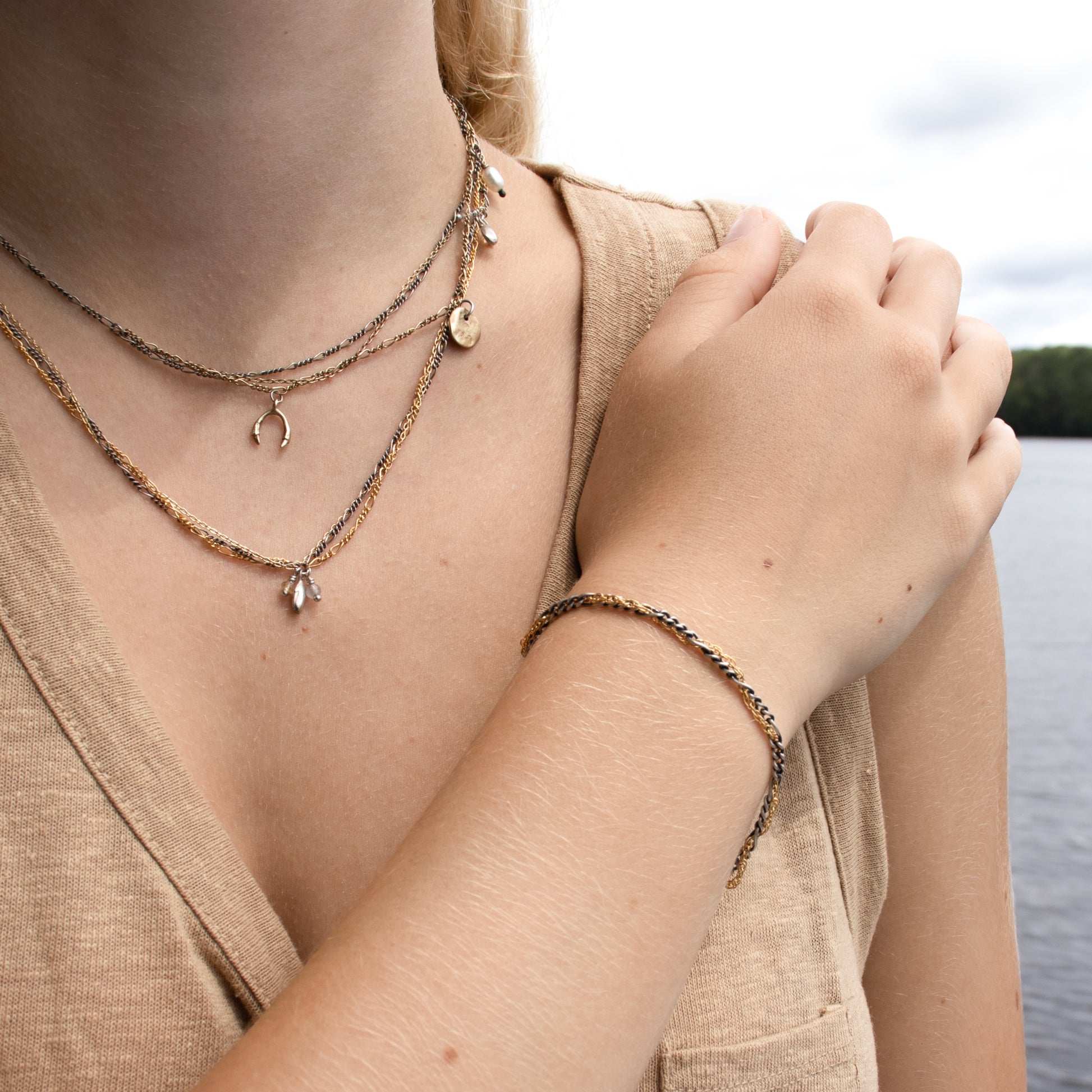 Hand-threaded reclaimed sterling silver and gold-filled mixed-chain bracelet 7 inches in diameter with our signature sterling silver Kria tag handmade and finished in our Catskills store-studio shown on model with mixed-chain charm necklaces.
