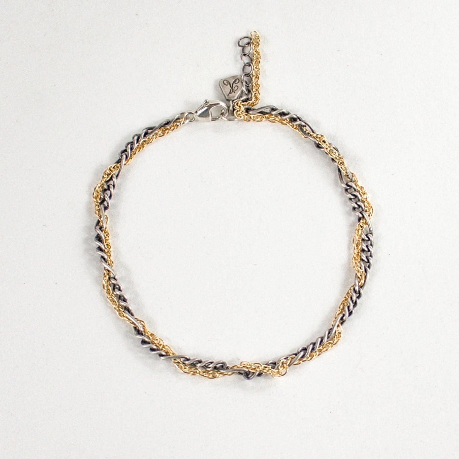 Hand-threaded sterling silver and gold-filled mixed-chain bracelet 7 inches in diameter with our signature sterling silver Kria tag