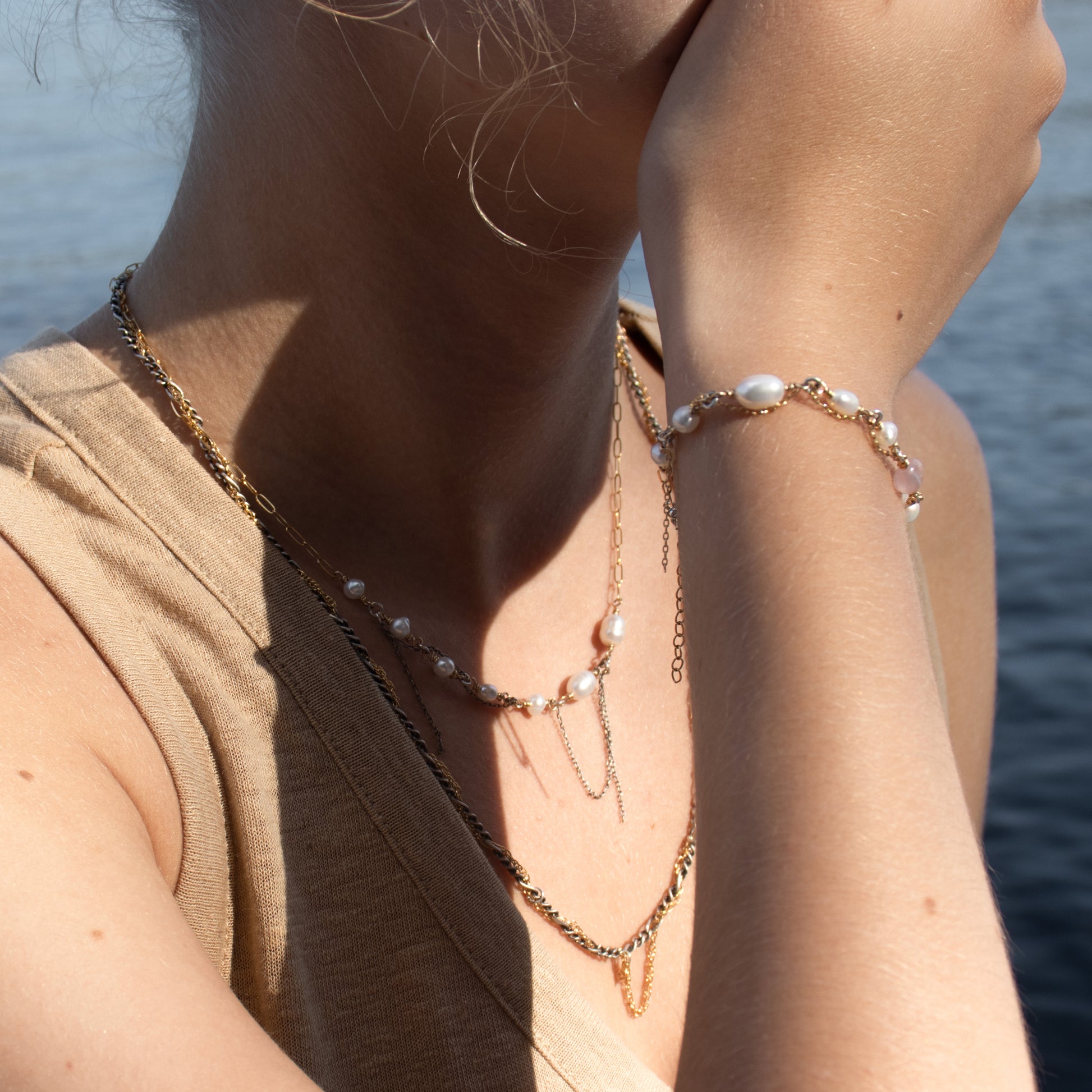 Gold-filled mixed-chain bracelet 7 inches in diameter hand-beaded with freshwater pearls and pink tourmaline bead threaded with gold-filled fine chain handmade and finished in our Catskills store-studio shown on model with matching necklace and threaded mixed-chain necklace.