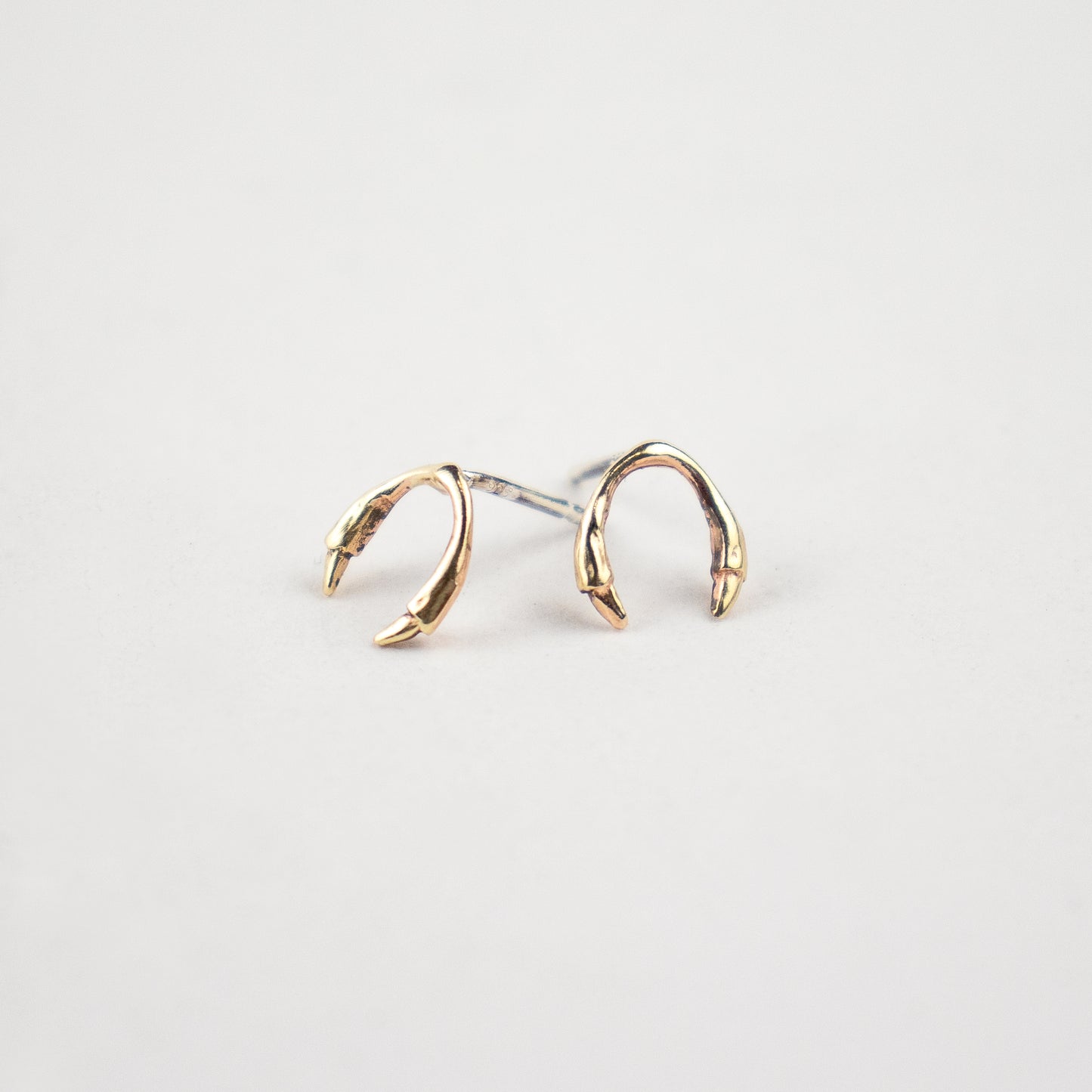 Solid reclaimed 10k gold branch horseshoe stud earrings on sterling silver posts handmade and finished in our Catskills store-studio.