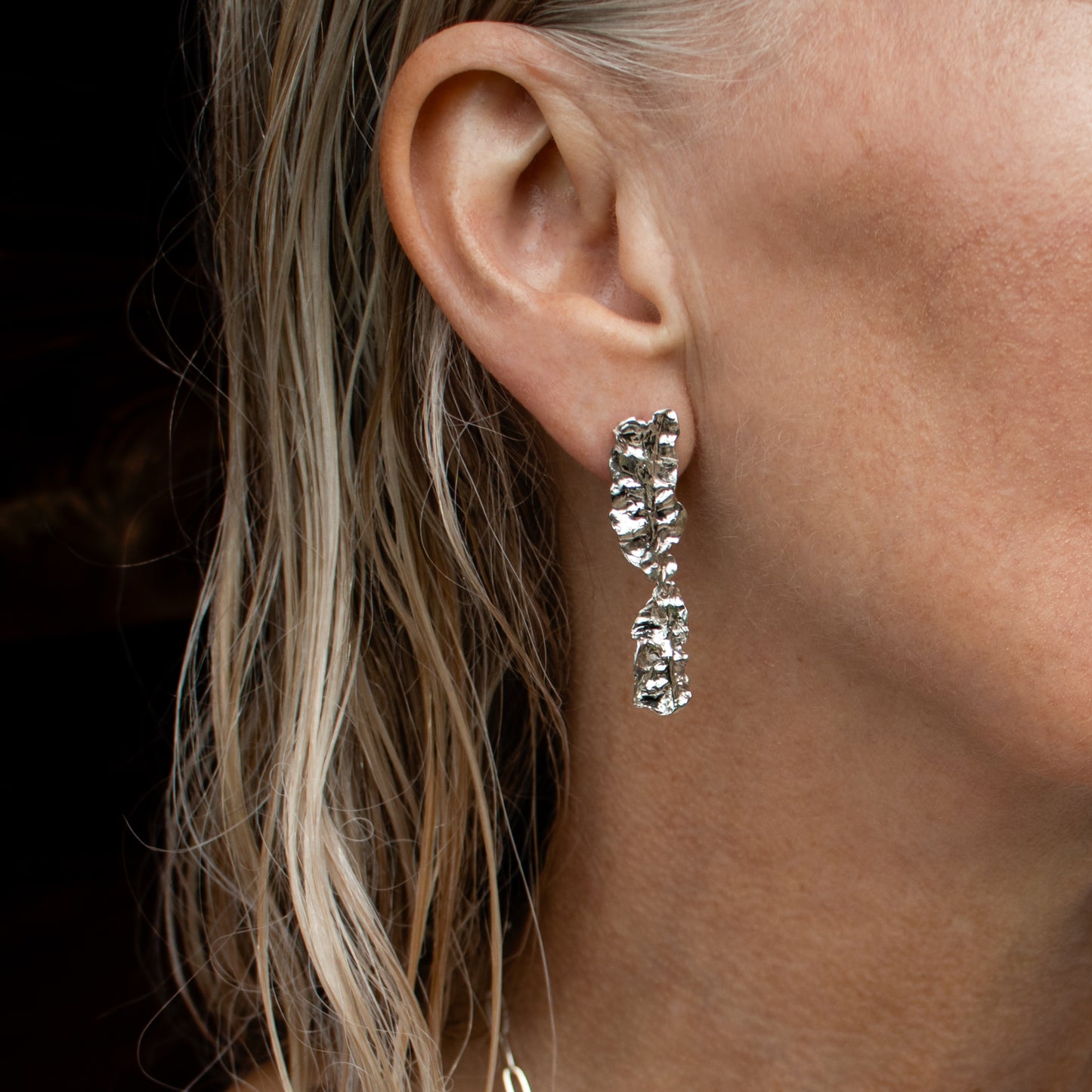 Reclaimed sterling silver double-wave seaweed stud earrings measuring 2 inches in length handmade and finished in our Catskills store-studio shown on model.