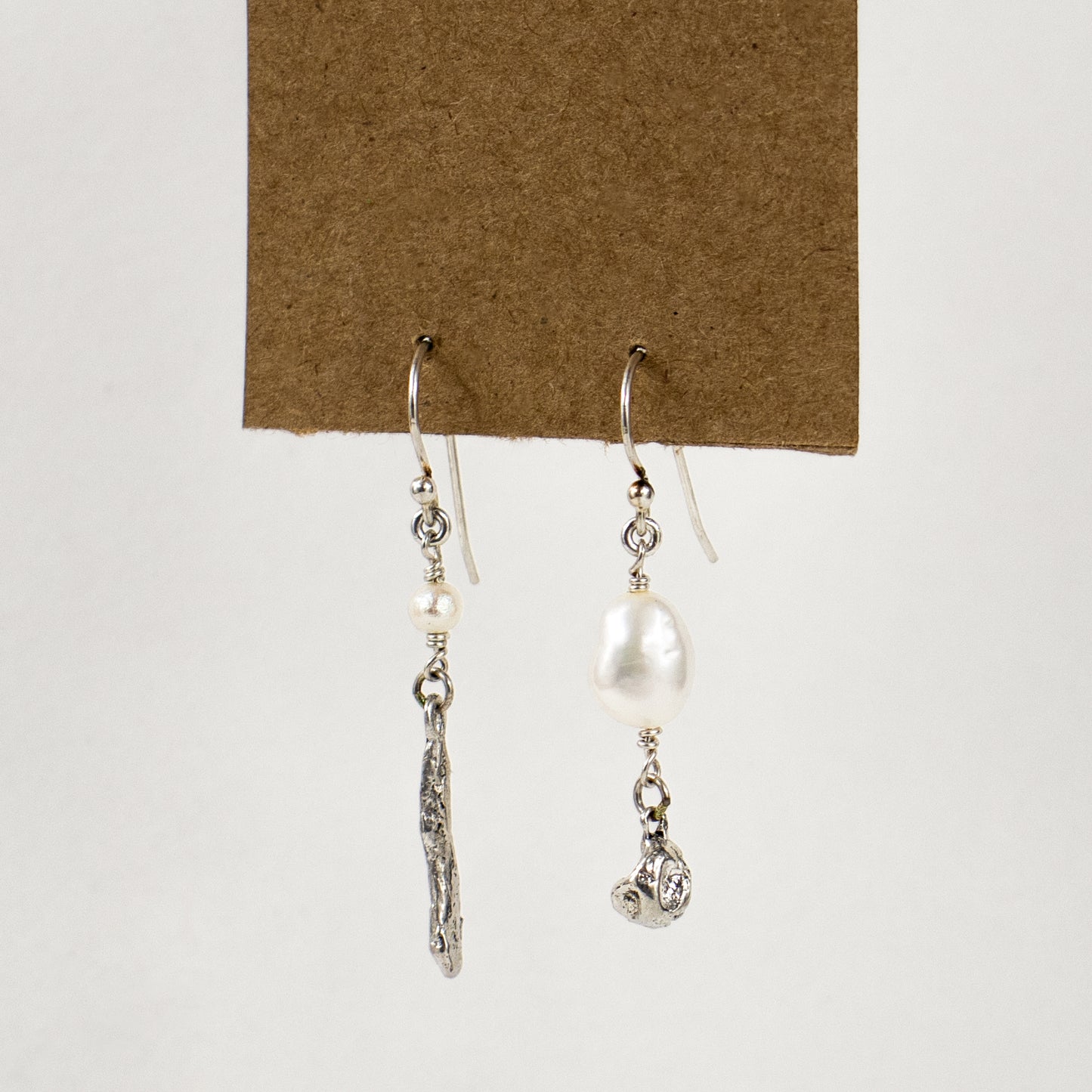 Asymmetric reclaimed sterling silver seaweed pods with freshwater pearls dangling from sterling hooks handmade and finished in our Catskills store-studio.