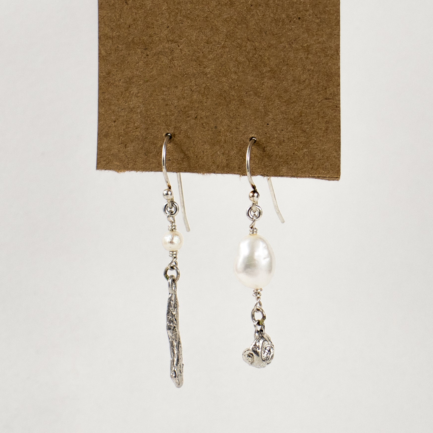 Asymmetric reclaimed sterling silver seaweed pods with freshwater pearls dangling from sterling hooks handmade and finished in our Catskills store-studio.