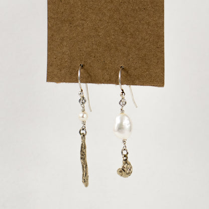 Asymmetric earrings of solid brass seaweed pods with freshwater pearls dangling from sterling silver hooks and handmade and finished in our Catskills store-studio