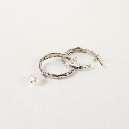 Sterling silver melted hoop earrings available in 1 inch and 0.5 inch diameters with one freshwater pearl handmade and finished in our Catskills store-studio