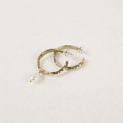 Brass melted hoop earrings available in 1 inch and 0.5 inch diameters with one freshwater pearl and sterling silver posts and backings handmade and finished in our Catskills store-studio