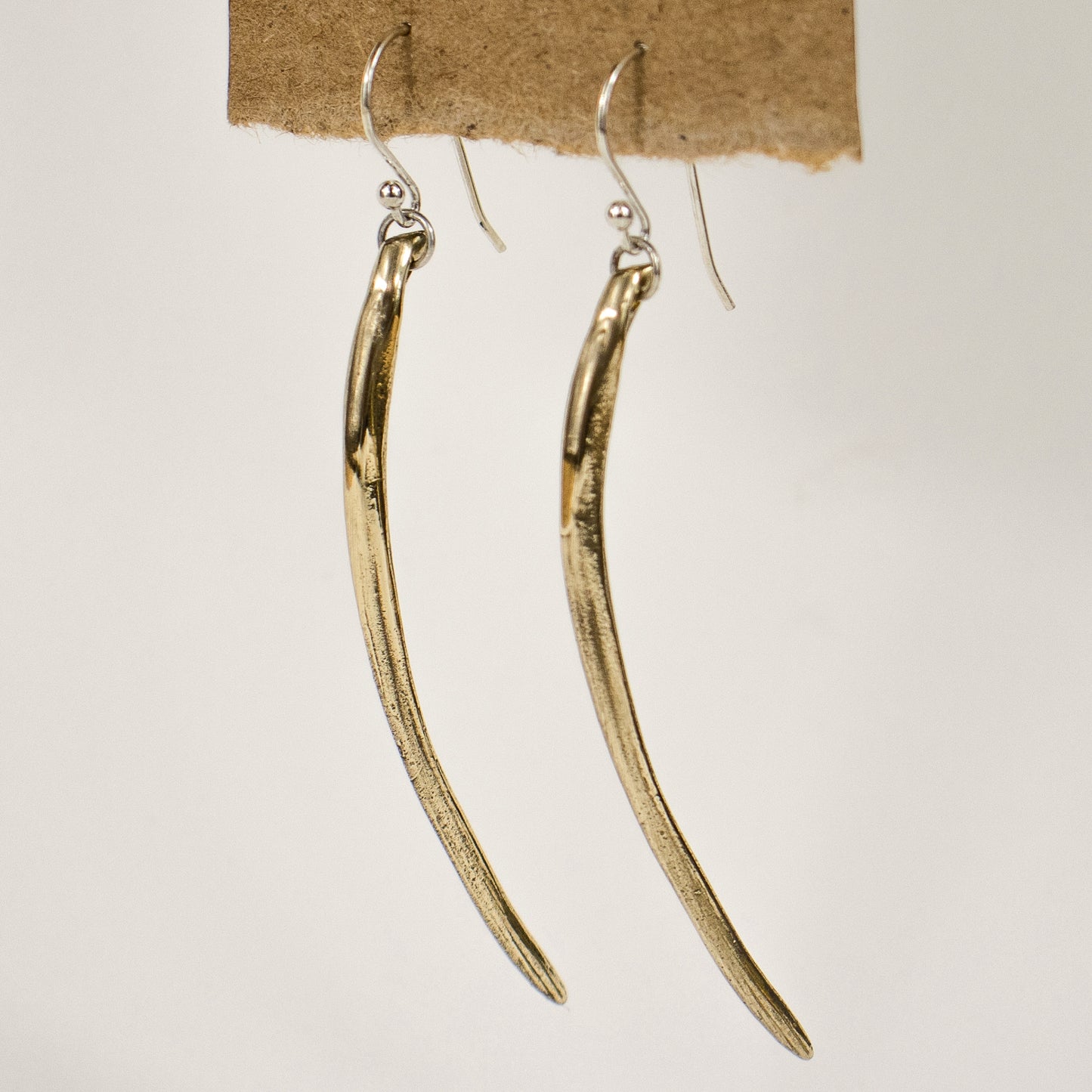 Solid reclaimed sterling silver or brass Cod branchiostegal measuring 2.25 inches in length dangling from a sterling hook and jump-ring. Handmade and finished in our Catskills store-studio