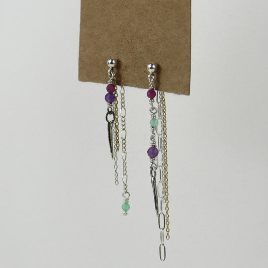 Sterling silver and gold-filled double mixed-chain tassels 2 inches at their longest dangling from sterling studs hand-beaded with ruby, amethyst, and chrysoprase and finished with tiny sterling and brass spikes hanging from paper tag on white background.