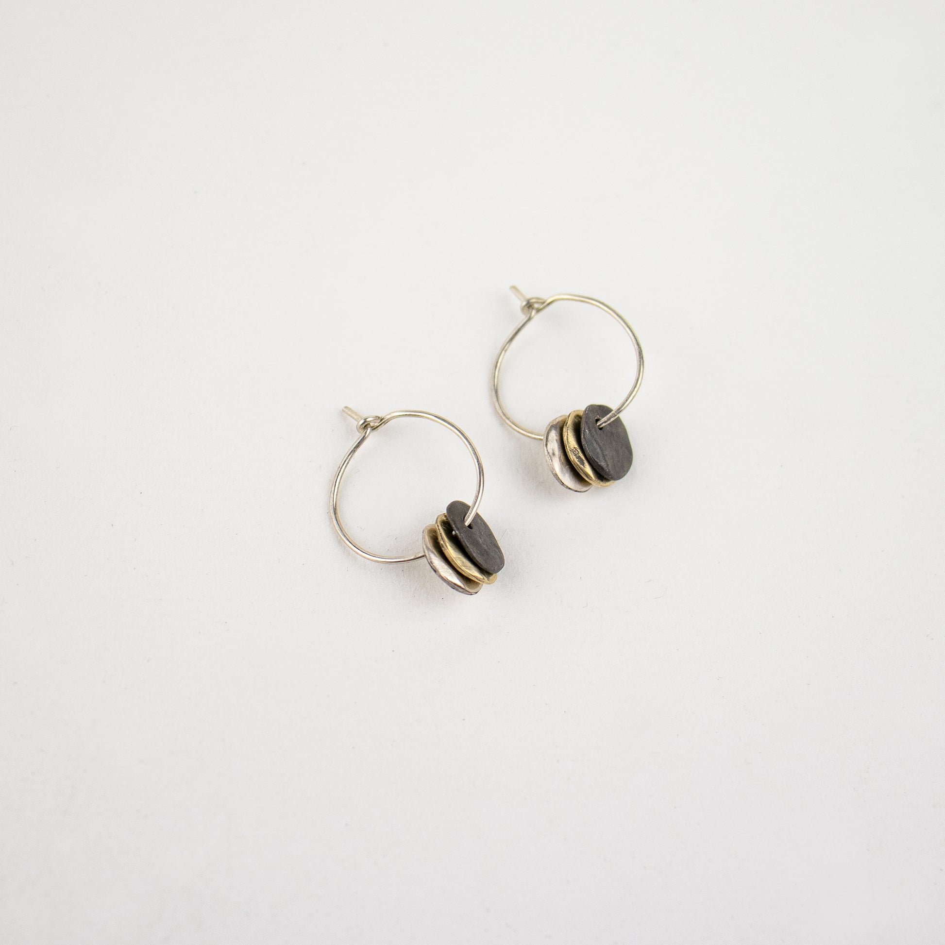 Solid reclaimed 10k gold, sterling silver, and oxidized sterling 0.5 inch rocks on 1 inch sterling handmade hoops and finished in our Catskills store-studio.