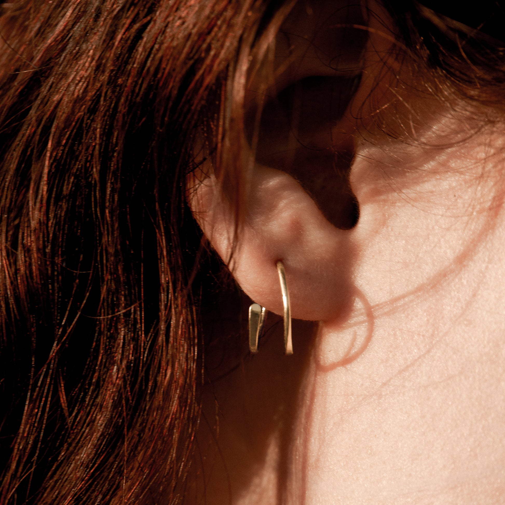 Solid reclaimed 10k gold spiral hoops 0.75 in diameter, hammer-finished in our Catskills store-studio, and available as singles to mix-and-match. Shown on model.