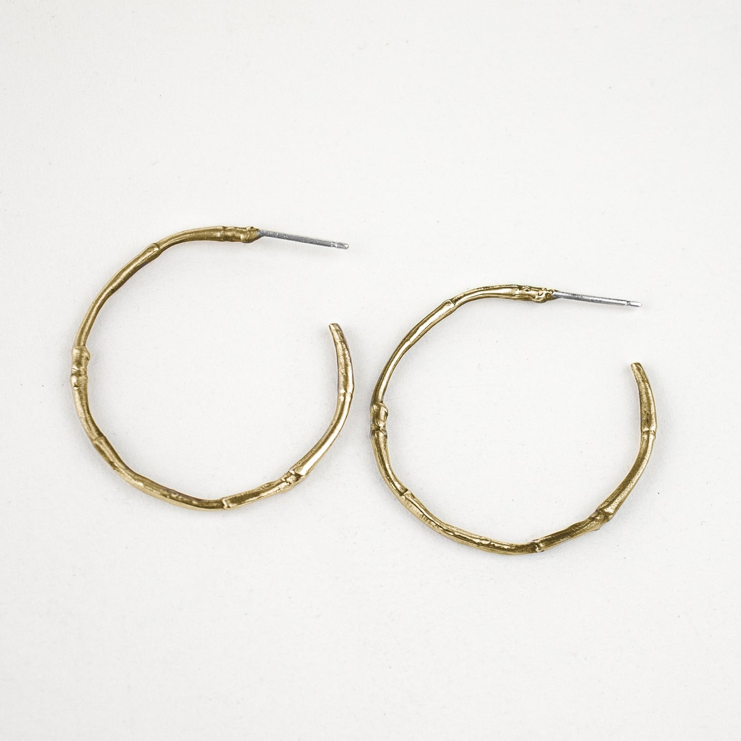 Solid reclaimed sterling silver or brass branch hoop earrings measuring 2 inches in diameter with sterling posts handmade and finished in our Catskills store-studio.