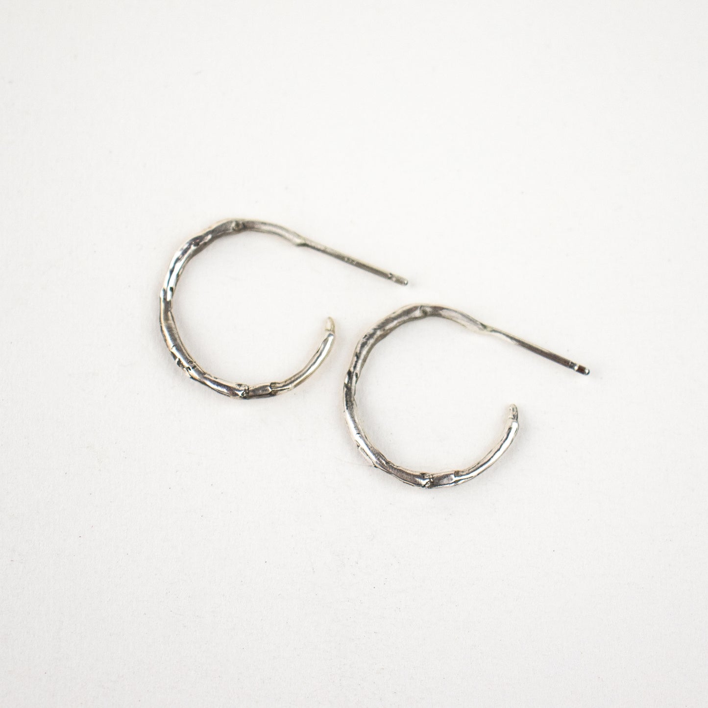 Solid reclaimed sterling silver small branch hoop earrings measuring 1 inch in diameter handmade and finished in our Catskills store-studio.