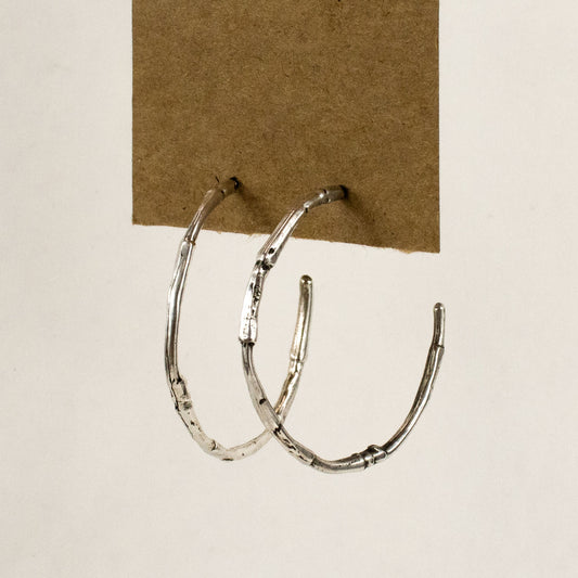 Solid sterling silver branch hoop earrings measuring 2 inches in diameter with sterling silver posts and handmade and finished in the Catskills store-studio.