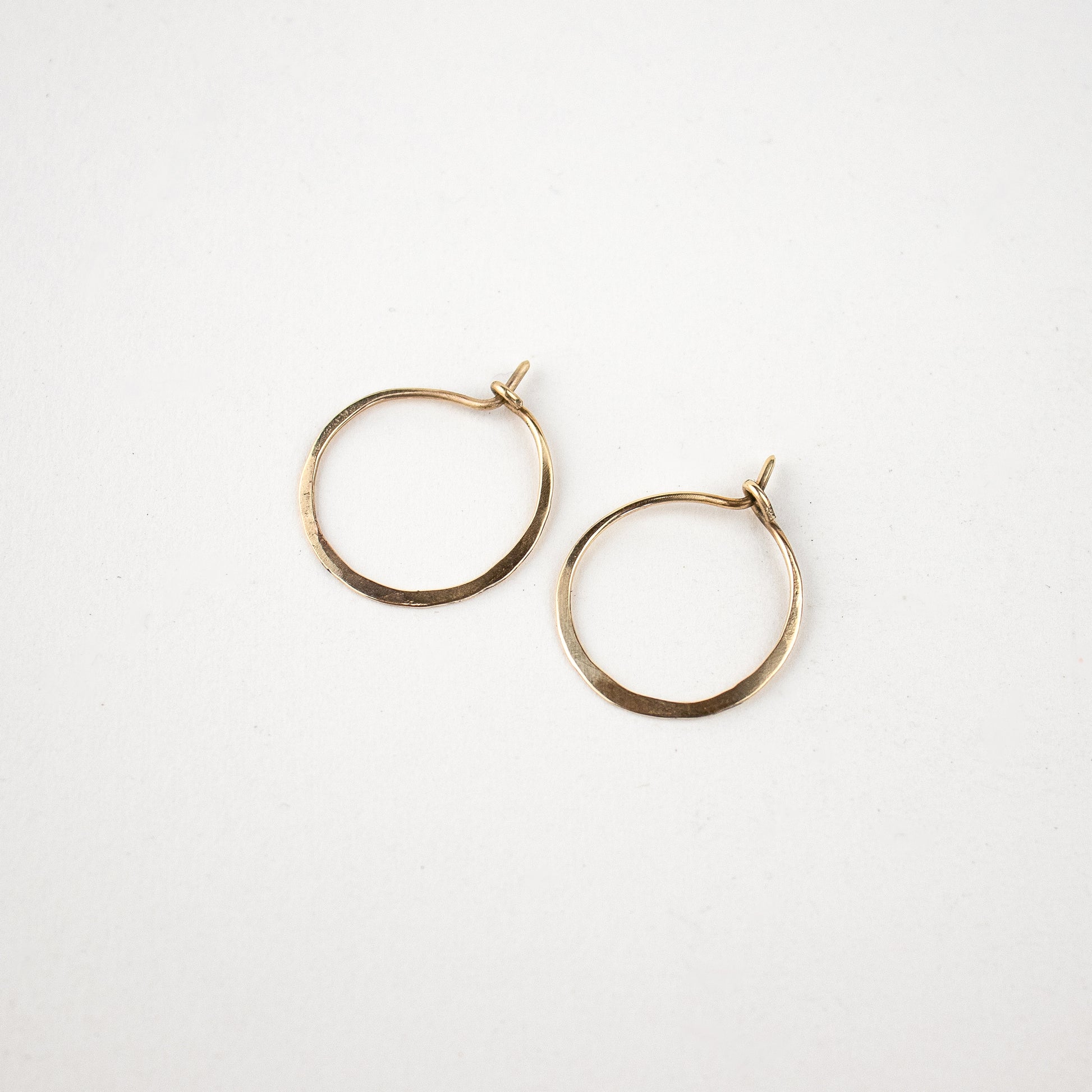 Solid reclaimed 10k gold hammer-finished hoop earrings measuring 1 inch in diameter handmade and finished in our Catskills store-studio.