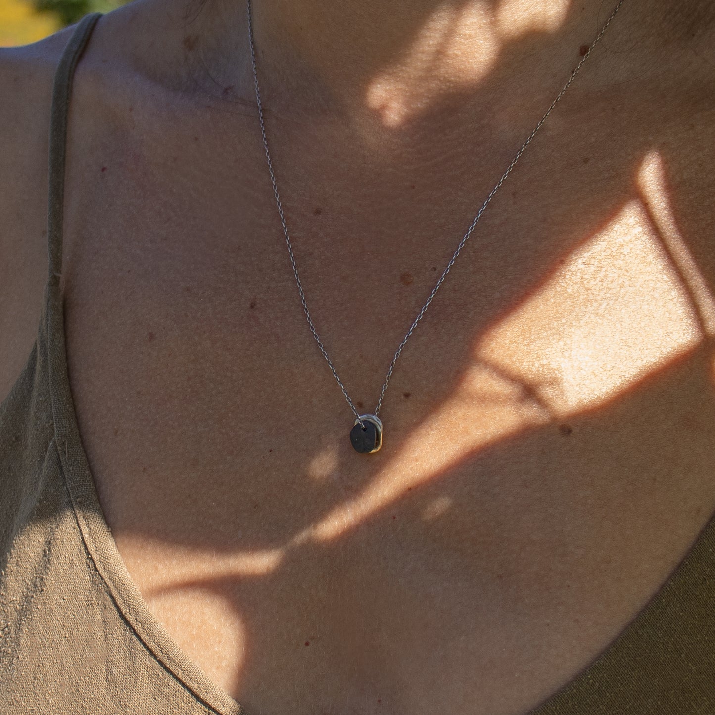 Solid reclaimed 10k gold, sterling silver, and oxidized sterling 0.5 inch rocks on 18 inch sterling fine-chain handmade and finished in our Catskills store-studio shown on model.