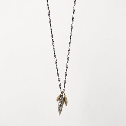 Solid reclaimed sterling silver bud and 10k gold seeds 0.25 - 0.75 inches in length on sterling Figaro chain adjustable 16 - 20 inches and handmade and finished in our Catskills store-studio.