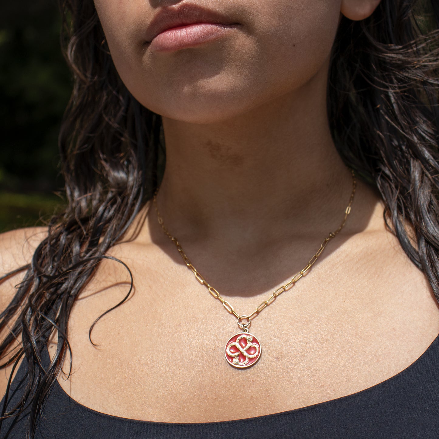 Solid reclaimed 10k gold Serpent Infinity Knot charm 20mm in diameter with your choice of black, lemon cream, or fire red enamel on gold-filled fine paperclip chain adjustable 20 - 24 inches handmade and finished in our Catskills store-studio shown on model in sunlight.