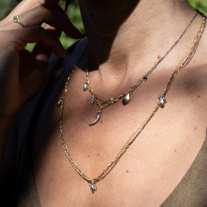 Solid reclaimed sterling silver Icelandic owl claw, two brass seeds, and chrysoprase, moonstone, labradorite and citrine beads on tangled sterling and gold-filled mixed-chains adjustable 16 - 20 inches handmade and finished in our Catskills store-studio shown on model in sunlight.