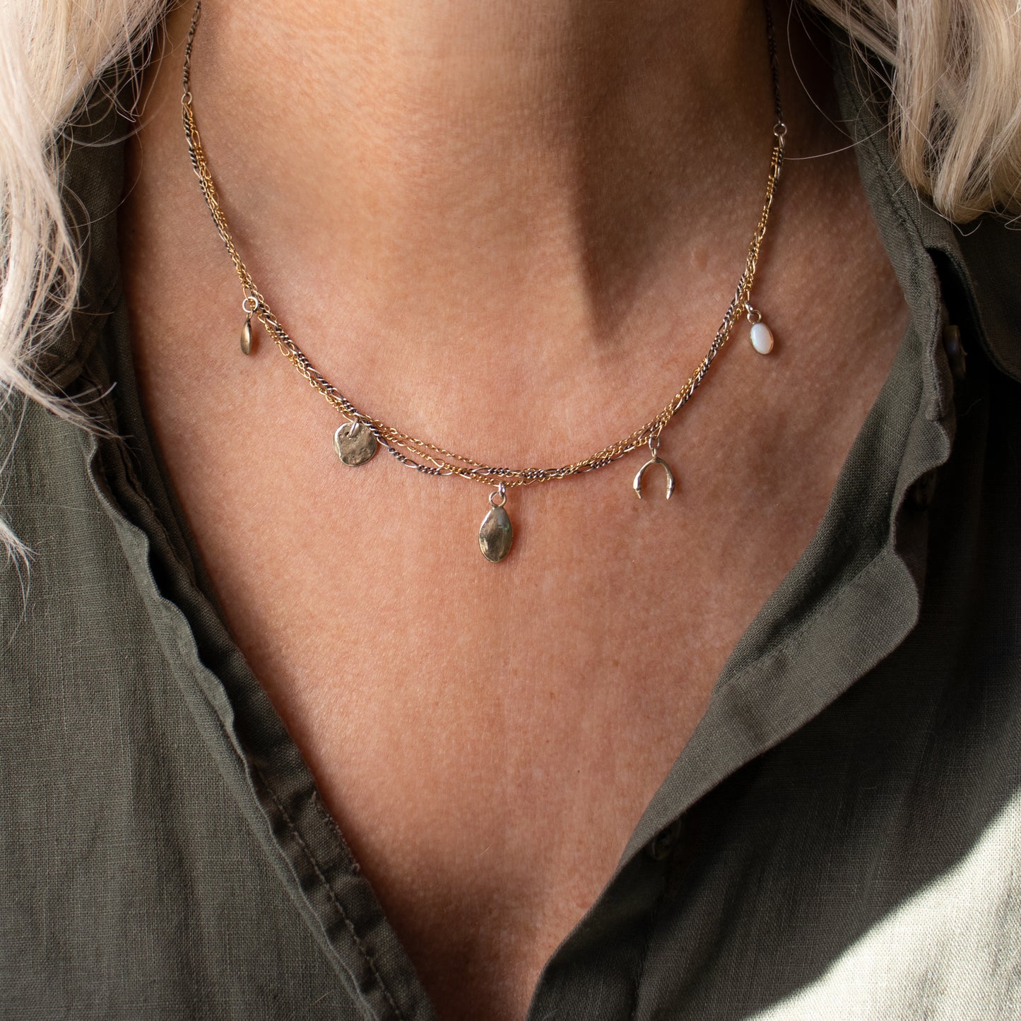 Tangled sterling silver and gold-filled chain necklace adjustable 15-18" with an opal and solid reclaimed 10k gold seeds, rock and horseshoe charms handmade and finished in our Catskills store-studio shown on model.