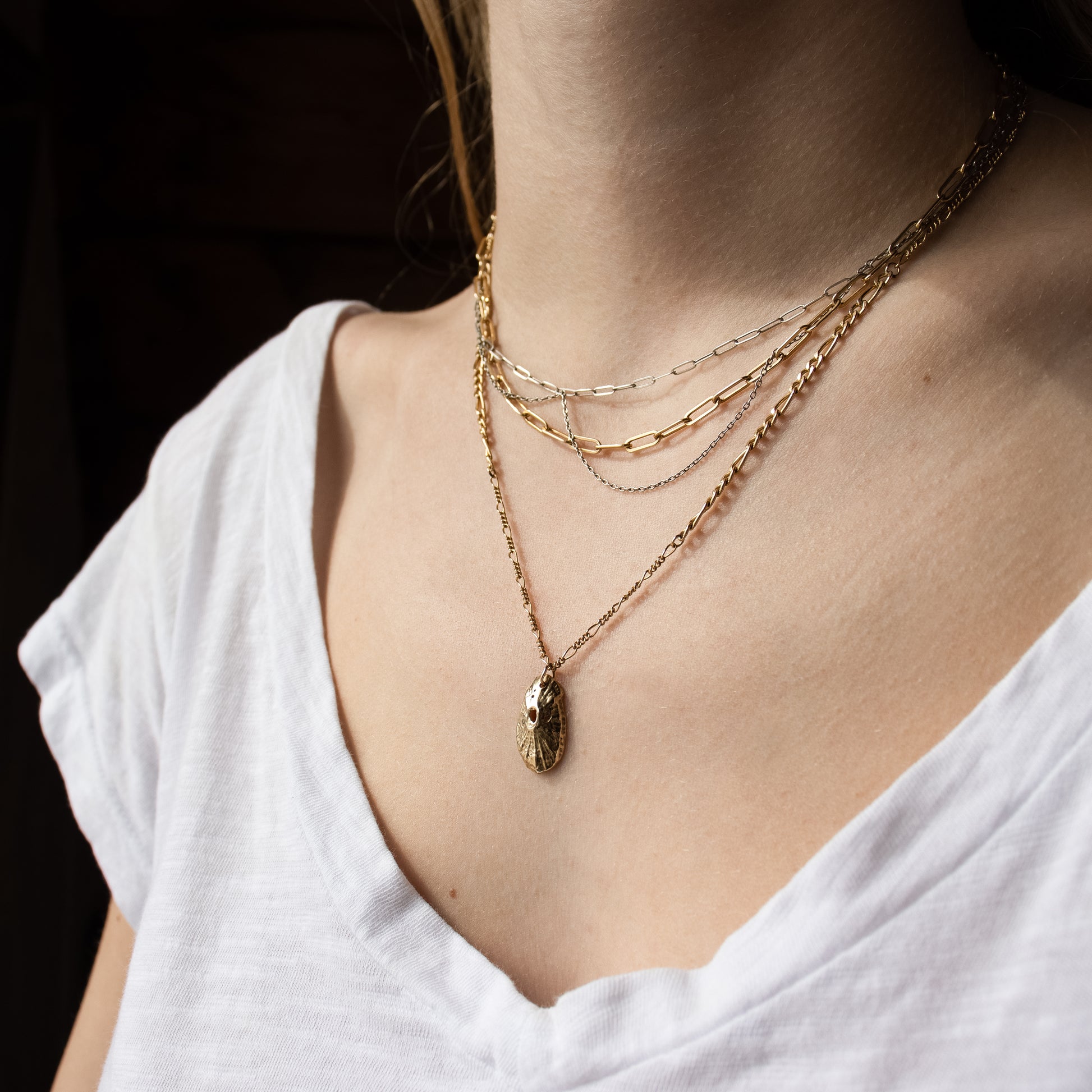 Solid reclaimed 10k gold Pacific keyhole shell pendant 0.75 inches in length on gold-filled mixed Figaro chain adjustable 18 - 20 inches and finished in our Catskills store-studio shown on model with mixed paperclip chain necklace.