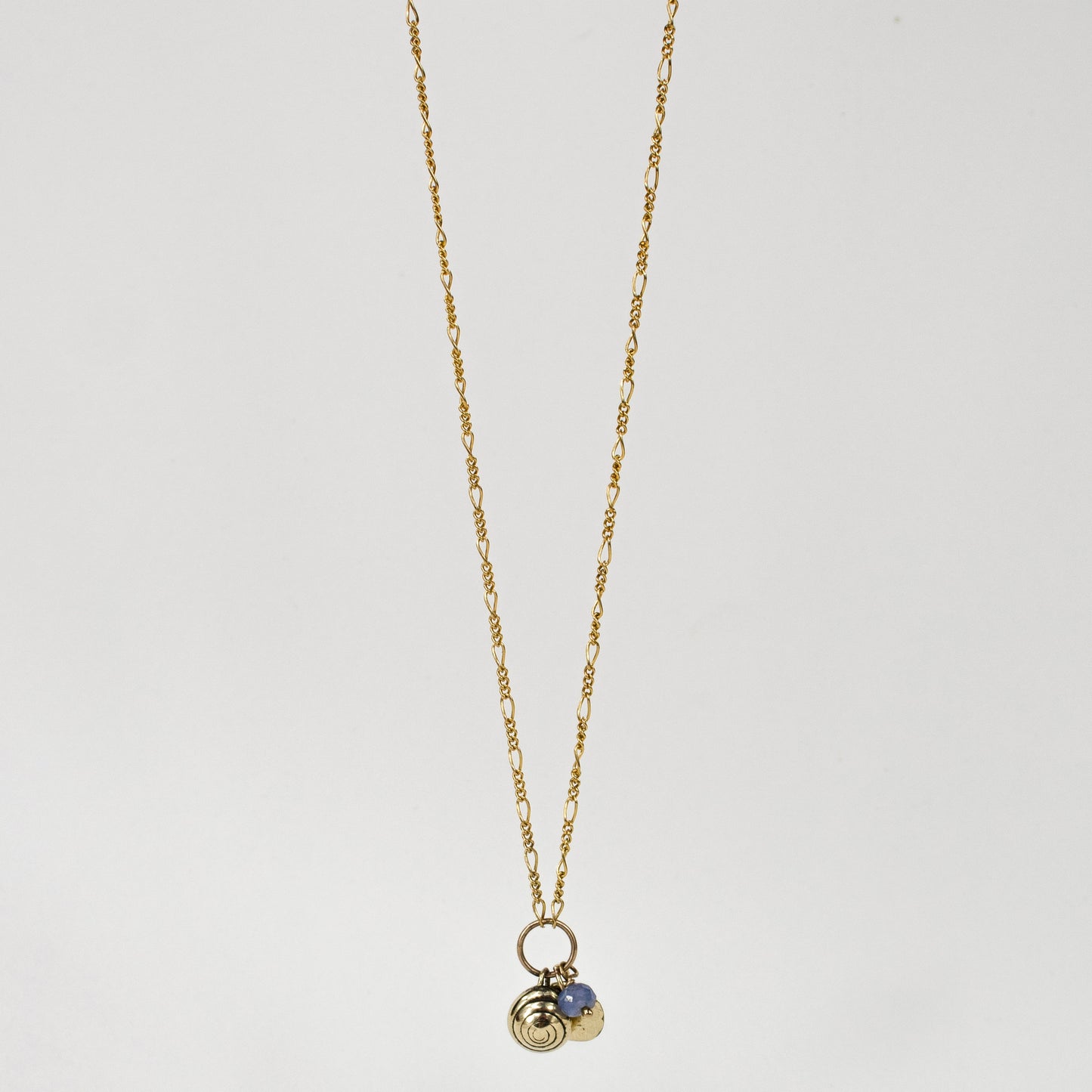 Solid reclaimed 10k gold spiral snail shell and rock disc charms with baby blue sapphire bead on gold-filled Figaro chain adjustable 18 -22 inches handmade and finished in our Catskills store-studio.