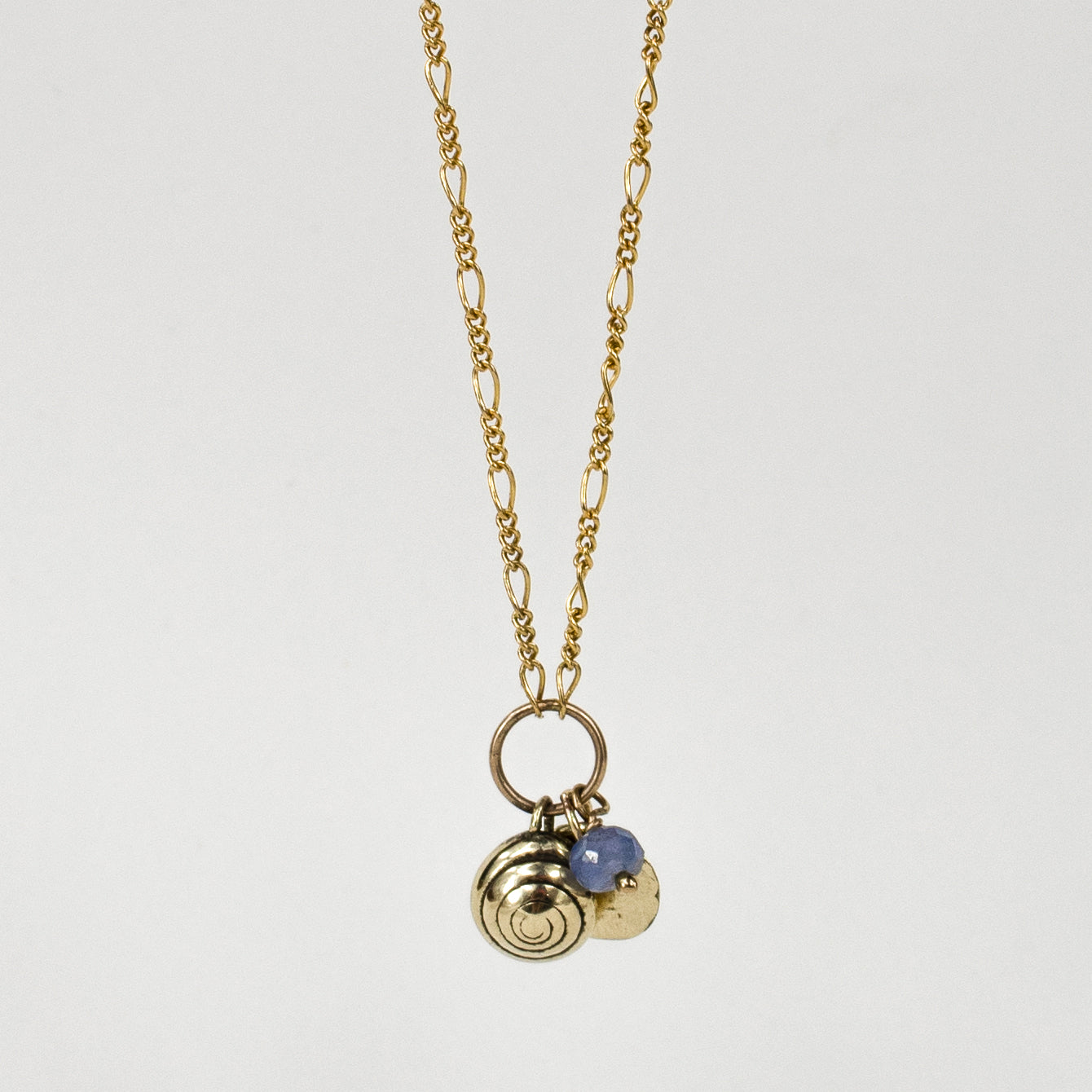 Solid reclaimed 10k gold spiral snail shell and rock disc charms with baby blue sapphire bead on gold-filled Figaro chain adjustable 18 -22 inches handmade and finished in our Catskills store-studio.