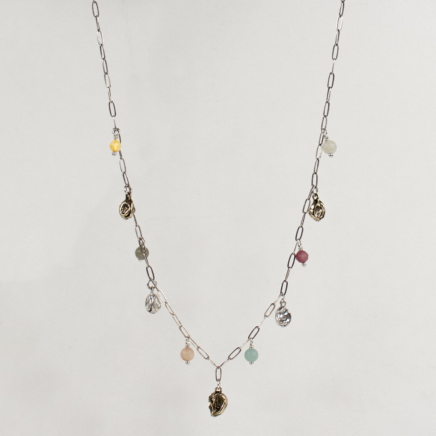 Five reclaimed brass seaweed pods, each measuring 5 mm, and six 4 mm multicolor beads on a fine sterling silver paperclip chain. Adjustable from 16–18 inches. Handmade and finished in our Catskills store-studio.