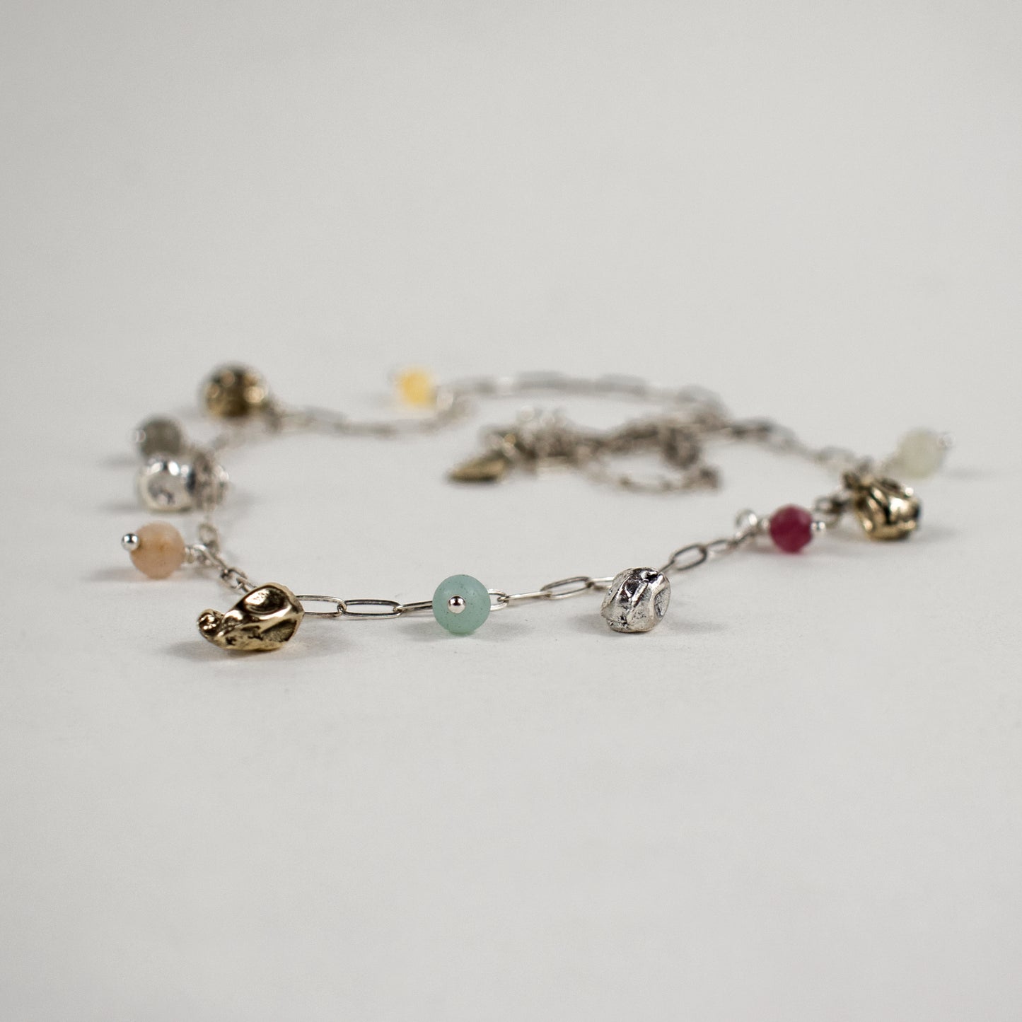 Five reclaimed brass seaweed pods, each measuring 5 mm, and six 4 mm multicolor beads on a fine sterling silver paperclip chain. Adjustable from 16–18 inches. Handmade and finished in our Catskills store-studio.