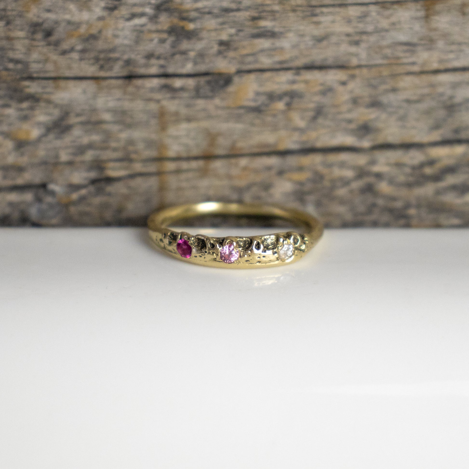 Solid reclaimed 14k gold Vomer ring with a 3 - 3.5 mm band-width set with two 2mm pink sapphires and a 2mm diamond.