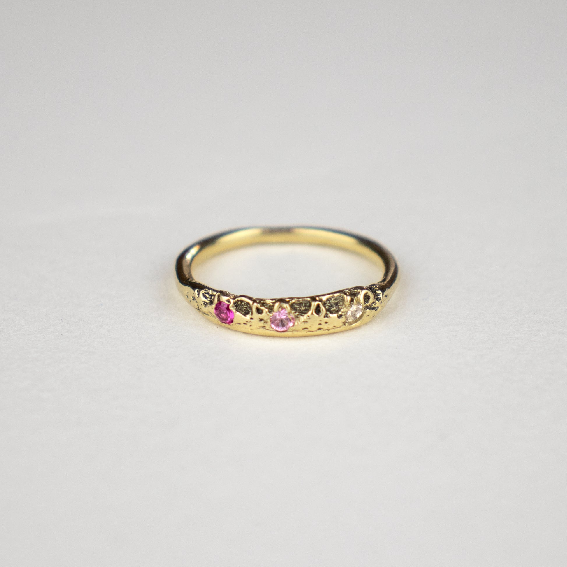 Solid reclaimed 14k gold Vomer ring with a 3 - 3.5 mm band-width set with two 2mm pink sapphires and a 2mm diamond.